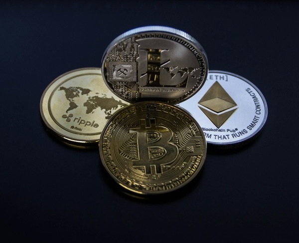 Bitcoin, Ethereum, and Ripple physical cryptocurrency coins on a dark background